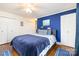Inviting main bedroom with a comfortable bed, blue accent wall, and ample closet space with hardwood floors at 5431 Park Rd, Charlotte, NC 28209
