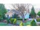 A charming home with mature trees, manicured hedges, and an attached two-car garage at 8430 Stoneman Pl, Charlotte, NC 28217