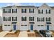 A row of townhomes featuring blue doors, white garages and siding, and neatly trimmed landscaping at 2409 Fathom Way, Charlotte, NC 28269