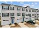 A row of townhomes featuring blue doors, white garages and siding, and neatly trimmed landscaping at 2409 Fathom Way, Charlotte, NC 28269