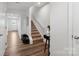 A bright hallway featuring hardwood floors, a staircase, and a door to the exterior at 2409 Fathom Way, Charlotte, NC 28269