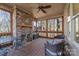 Relaxing screened porch with stone fireplace, wicker furniture, and wood floors at 404 Yorkfield Dr, Shelby, NC 28150
