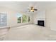 Gathering room with fireplace, large windows, and ceiling fan at 11131 Cypress View Dr, Charlotte, NC 28262