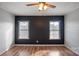 Bright bedroom with two windows, dark accent wall, and laminate wood floor at 202 Mountain View Dr, Taylorsville, NC 28681