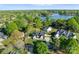 Breathtaking aerial view of a serene lakefront home with a luxurious pool and lush landscape at 20400 Rainbow Cir, Cornelius, NC 28031