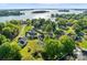 Scenic aerial view of a lakefront home with a pool surrounded by mature trees and landscaping at 20400 Rainbow Cir, Cornelius, NC 28031