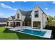Beautiful modern farmhouse featuring a pristine pool, patio, and manicured lawn at 20400 Rainbow Cir, Cornelius, NC 28031