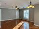 Bright living room with hardwood floors, ceiling fan, and natural light streaming through the window at 2518 Cranbrook Ln, Charlotte, NC 28207