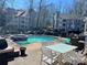 Inviting community pool and hot tub surrounded by seating, with residential buildings in the background at 2518 Cranbrook Ln, Charlotte, NC 28207