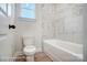 Bathroom with a bathtub, marble tile, and a window for natural light at 3252 Mcharney Dr # 37, Harrisburg, NC 28075