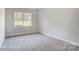 Simple bedroom with gray carpeting and a window at 3252 Mcharney Dr # 37, Harrisburg, NC 28075