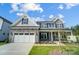 Two-story home with stone accents and a three-car garage at 3252 Mcharney Dr # 37, Harrisburg, NC 28075