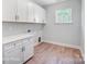 Laundry room with white cabinets and wood-look flooring at 3252 Mcharney Dr # 37, Harrisburg, NC 28075