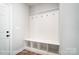 White mudroom with bench seating and coat hooks at 3252 Mcharney Dr # 37, Harrisburg, NC 28075