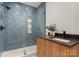 Stylish bathroom with sleek vanity, sink, and a shower featuring modern blue herringbone tile at 4026 Chevington Rd # 102, Charlotte, NC 28226