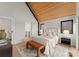 Bright bedroom featuring a vaulted wood ceiling, neutral walls, and an upholstered bed with a brown leather bench at the foot at 4026 Chevington Rd # 103, Charlotte, NC 28226