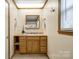 Bathroom vanity with wood cabinets, granite countertops, and framed mirror above a white sink at 110 Yorktowne St, Fort Mill, SC 29715