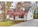 View of charming home with American flag, mature trees, long driveway and manicured landscaping at 110 Yorktowne St, Fort Mill, SC 29715