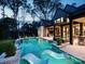 Illuminated backyard featuring a modern pool, in-pool loungers, and inviting outdoor seating areas at 116 Hunt Camp Trl # 11, Davidson, NC 28036