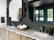 Stylish bathroom showcasing dual sinks, dark accent wall, and elegant lighting fixtures with modern mirrors at 116 Hunt Camp Trl # 11, Davidson, NC 28036