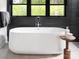 Luxurious bathroom featuring a modern tub, black tiled wall, and a view of the trees through the window at 116 Hunt Camp Trl # 11, Davidson, NC 28036