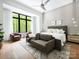 Bright bedroom featuring a comfortable gray bed, seating area and beautiful views of the outside greenery at 116 Hunt Camp Trl # 11, Davidson, NC 28036