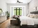 Light-filled bedroom featuring a seating area, light wood floors, and a large window providing views of the trees at 116 Hunt Camp Trl # 11, Davidson, NC 28036