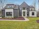 Contemporary home featuring a unique architectural design, stone accents, dark siding and a well-maintained front lawn at 116 Hunt Camp Trl # 11, Davidson, NC 28036