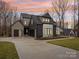 Striking modern home showcasing unique architecture and professional landscaping, including a spacious driveway and manicured lawn at 116 Hunt Camp Trl # 11, Davidson, NC 28036