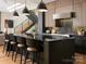Sleek kitchen featuring a dark island with seating, wooden cabinetry, and modern fixtures at 116 Hunt Camp Trl # 11, Davidson, NC 28036