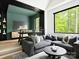 Comfortable living room area with a gray sectional couch, black coffee table and views of the greenery outside at 116 Hunt Camp Trl # 11, Davidson, NC 28036