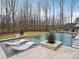 Luxury pool area with in-pool loungers, manicured landscaping, and lush greenery at 116 Hunt Camp Trl # 11, Davidson, NC 28036