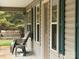 Inviting porch with comfortable chairs, a swing and green shutters, perfect for relaxing and enjoying the outdoors at 369 Pinecrest Cir, Troy, NC 27371
