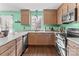 L-shaped kitchen with wood cabinets and granite countertops at 697 Maple Ridge Cir, Salisbury, NC 28147