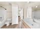 Bright bathroom featuring a tub, large mirror, and vanity with tan cabinets at 8633 Sawleaf Ct, Charlotte, NC 28215