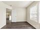 A bedroom features neutral walls, a single window, and gray wood flooring throughout at 8633 Sawleaf Ct, Charlotte, NC 28215