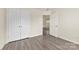 A bedroom features neutral walls, modern closet doors, and gray wood flooring throughout at 8633 Sawleaf Ct, Charlotte, NC 28215