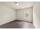 A bedroom features neutral walls, a window for natural light, and gray wood flooring throughout at 8633 Sawleaf Ct, Charlotte, NC 28215