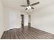 Spacious bedroom with a ceiling fan, plank flooring, and multiple access doors at 8633 Sawleaf Ct, Charlotte, NC 28215