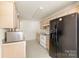 A well-lit kitchen showcases tan cabinetry and appliances, with a microwave on the countertop at 8633 Sawleaf Ct, Charlotte, NC 28215