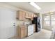 Cozy kitchen with white appliances and tan cabinets plus a window for natural light at 8633 Sawleaf Ct, Charlotte, NC 28215