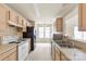 Kitchen with white appliances, tan cabinets, and a view into the dining area at 8633 Sawleaf Ct, Charlotte, NC 28215