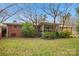 View of the home's brick exterior, screened in back porch, and lush backyard with mature trees at 1008 Candlewood Ln, Rock Hill, SC 29730