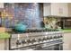 Close up shot of a stainless steel gas range with blue tiled backsplash in a modern kitchen at 1008 Candlewood Ln, Rock Hill, SC 29730