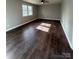 Bright living room with dark brown wood-look flooring and large windows at 129 Mapleleaf Rd, Statesville, NC 28625