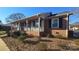 Home exterior featuring brick siding, a front porch, and updated windows at 1308 Princeton Ave, Gastonia, NC 28054