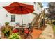 Glass-top patio table with chairs under red umbrella, brick flooring, wooden stairs at 19830 Madison Village Dr # 65, Cornelius, NC 28031