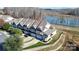 Aerial shot of townhomes with a manicured lawn and a tranquil lake in the background at 4146 La Crema Dr, Charlotte, NC 28214