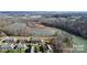 Aerial view showcases townhome community nestled by a scenic lake, surrounded by wooded landscape at 4146 La Crema Dr, Charlotte, NC 28214
