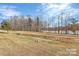Expansive backyard with a view of a serene lake, surrounded by trees and lush greenery at 4146 La Crema Dr, Charlotte, NC 28214